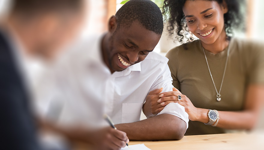 couple in real estate advising happy couple purchasing a home smiling black african american man is signing closing documents representing billings tubb and wright law firm real estate experience practice